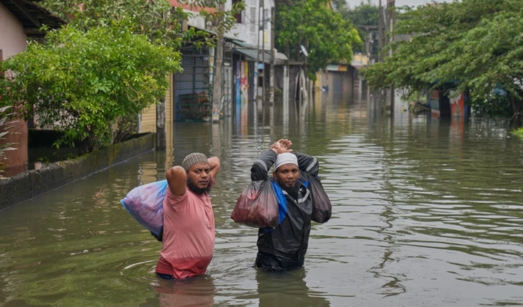 Flood victims wade through water in Colombo, Sri Lanka, Saturday, Nov, 29, 2025. (AP Photo/Eranga Jayawardena)