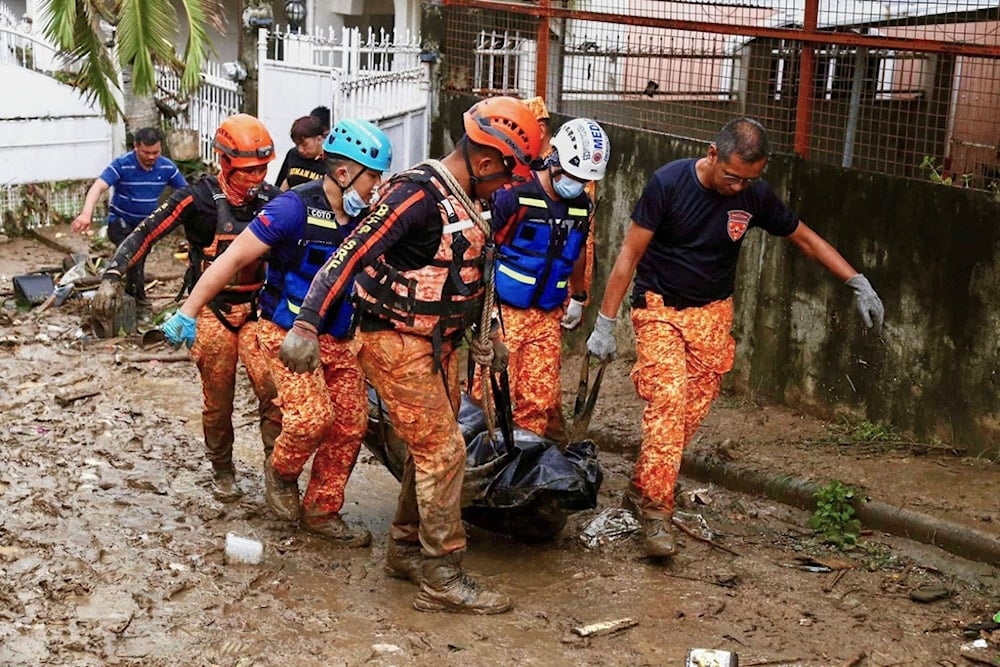 Rescue workers walk carrying a body bag after flooding caused by Typhoon Kalmaegi in Cebu city, central Philippines, Tuesday, Nov. 4, 2025. (AP Photo/Jacqueline Hernandez)