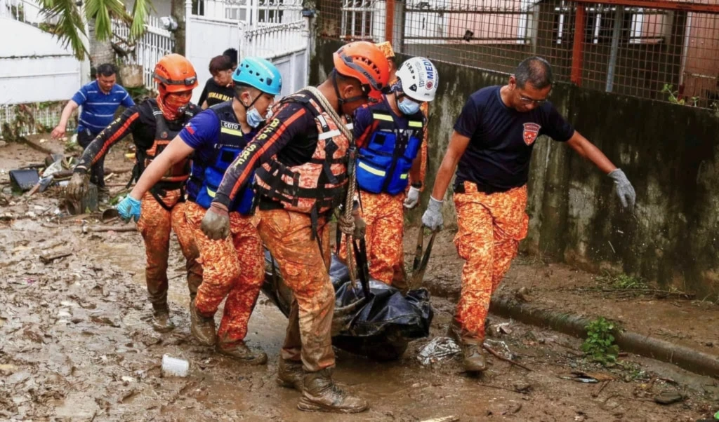 Rescue workers walk carrying a body bag after flooding caused by Typhoon Kalmaegi in Cebu city, central Philippines, Tuesday, Nov. 4, 2025. (AP Photo/Jacqueline Hernandez)