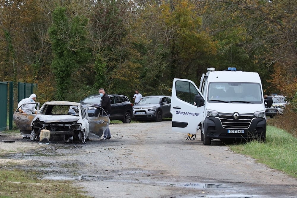 Investigators inspect the burned car after a motorist deliberately rammed pedestrians and cyclists across two neighboring towns on the Ile d'Oleron, Wednesday, November 5, 2025 (AP)