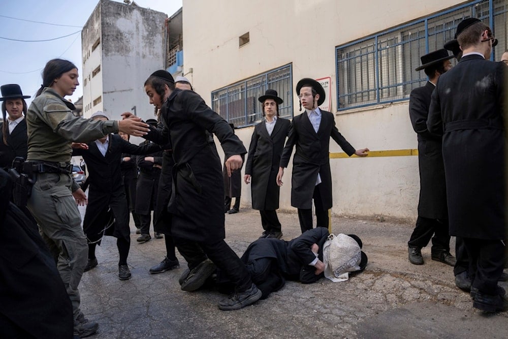 Israeli police officers scuffle with ultra-Orthodox Jewish men during a protest against a potential new draft law which could end their exemptions from military service in Jerusalem, Thursday, October 31, 2024. (AP Photo/Ohad Zwigenberg)