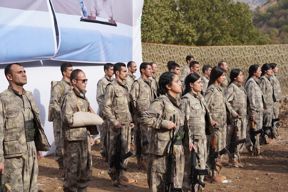Kurdistan Workers' Party (PKK) fighters, who reportedly withdrew from Turkey with their weapons, stand to attention during a ceremony in the Qandil area of northern, Iraq, Sunday, Oct 26, 2025 (AP)