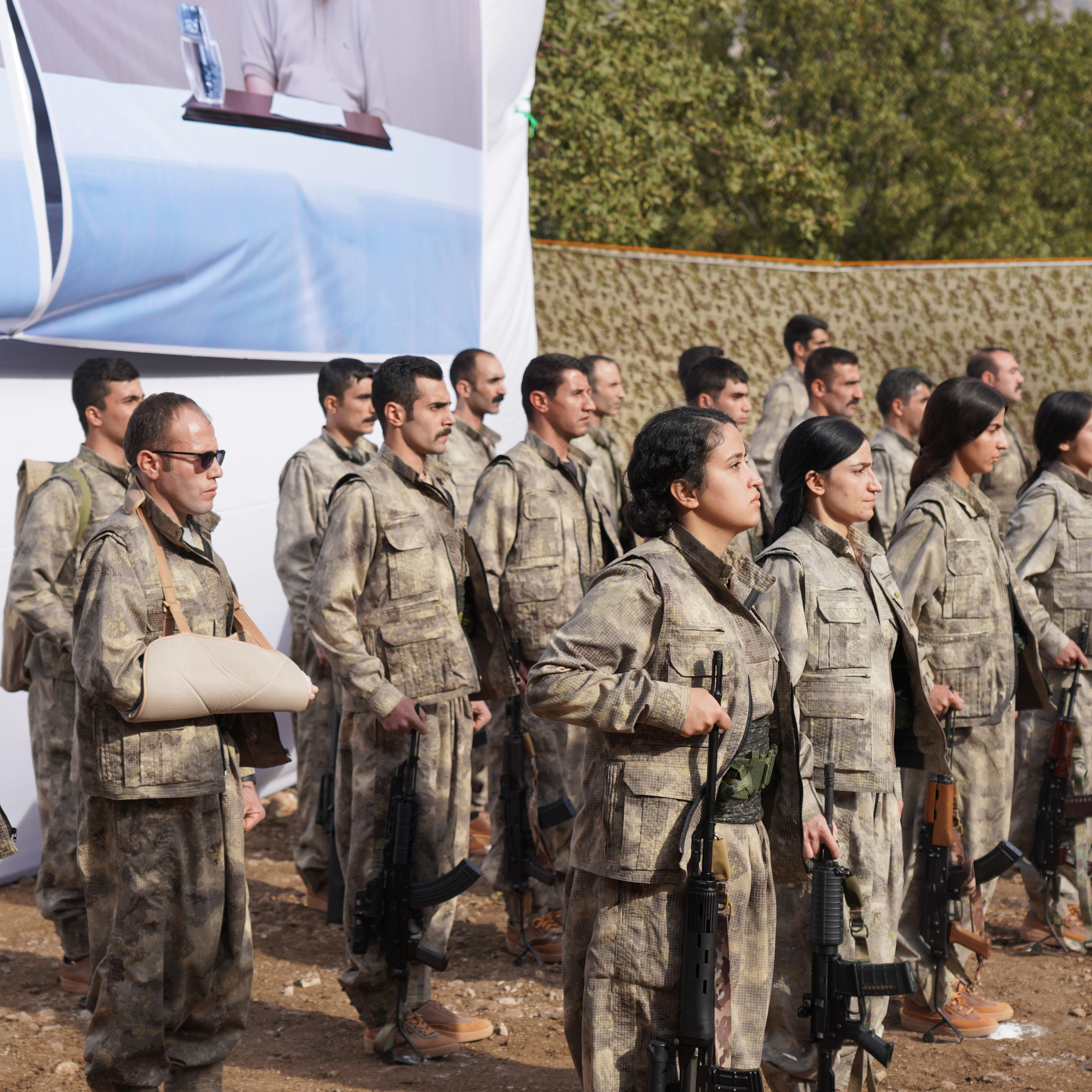 Kurdistan Workers' Party (PKK) fighters, who reportedly withdrew from Turkey with their weapons, stand to attention during a ceremony in the Qandil area of northern, Iraq, Sunday, Oct 26, 2025 (AP)