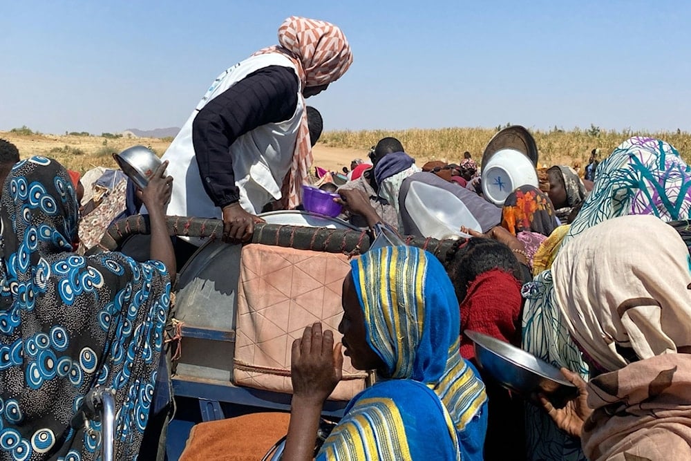Sudanese who fled el-Fasher city, after Sudan's paramilitary forces killed hundreds of people in the western Darfur region, crowd to receive food at their camp in Tawila, Sudan, Sunday, November 2, 2025 (AP) 