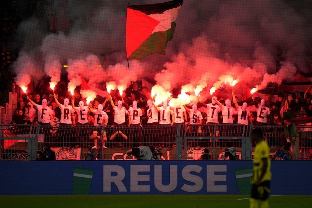 Celtic fans waving a Palestinian flag hold smoke flares during the Champions League opening phase soccer match between Borussia Dortmund and Celtic FC at the BVB Stadion in Dortmund, Germany, Tuesday, Oct. 1, 2024 (AP)