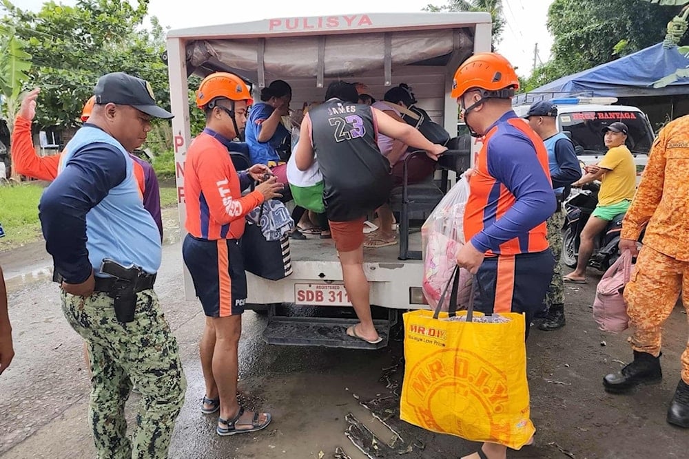In this photo provided by the Philippine Coast Guard, rescuers evacuate people to safer grounds in Quezon province, eastern Philippines as Typhoon Fung-wong enters the country on Sunday November 9 2025. (Philippine Coast Guard via AP)