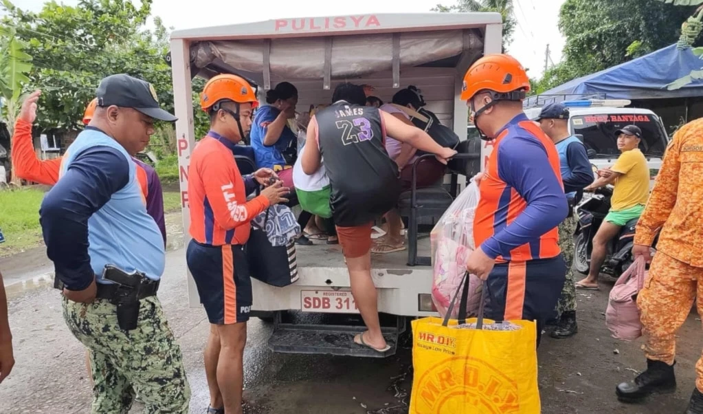 In this photo provided by the Philippine Coast Guard, rescuers evacuate people to safer grounds in Quezon province, eastern Philippines as Typhoon Fung-wong enters the country on Sunday November 9 2025. (Philippine Coast Guard via AP)