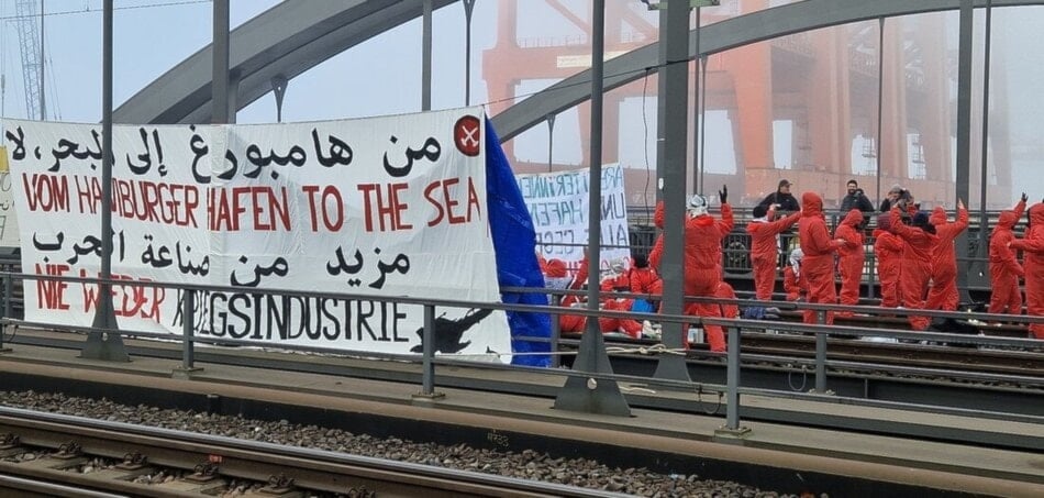 Photo of German activist blocking the Hamburg bridge in protest to Germany's arming of 