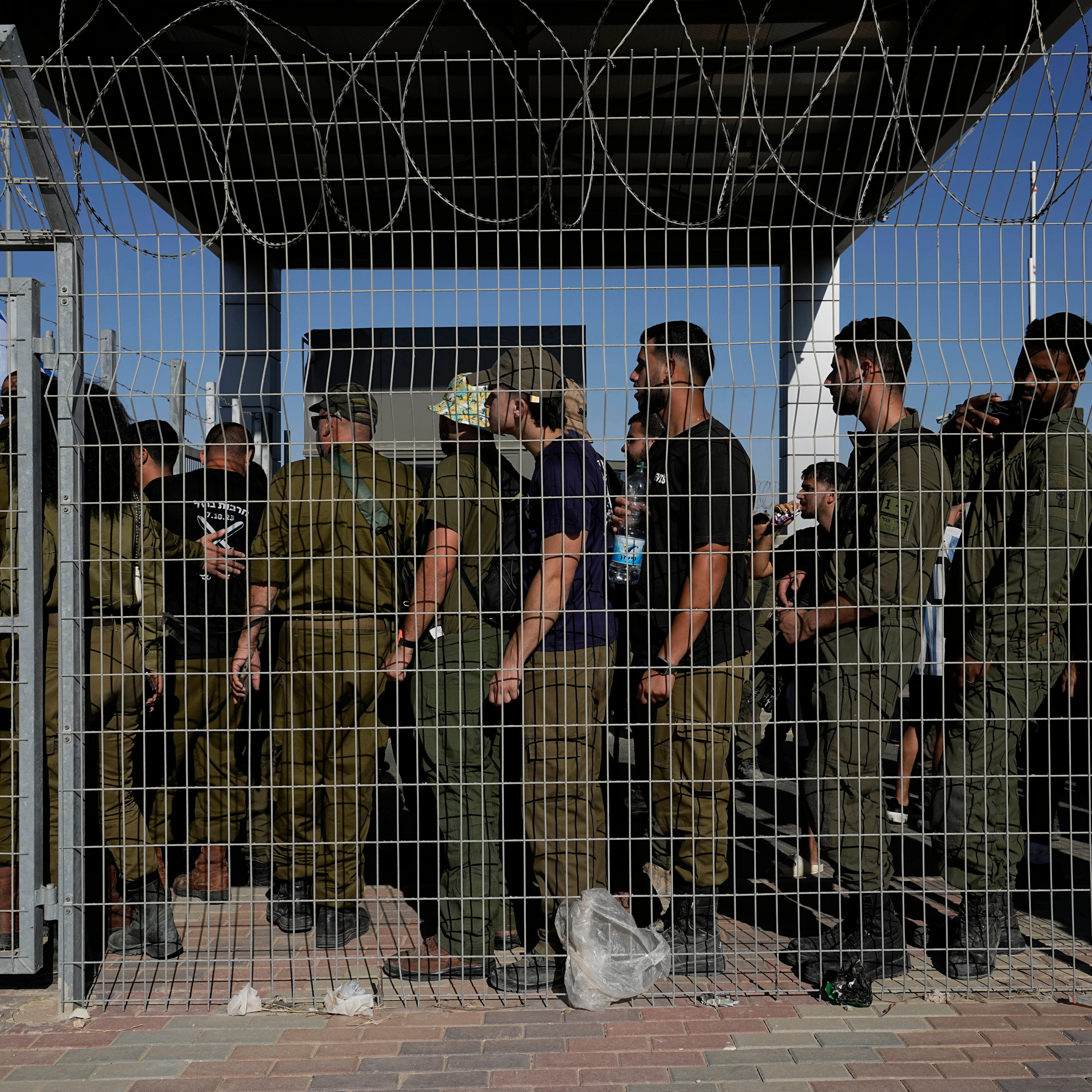 Israeli soldiers gather at the gate to the Sde Teiman military base, as people protest in support of soldiers being questioned for detainee abuse, July 29, 2024 (AP)
