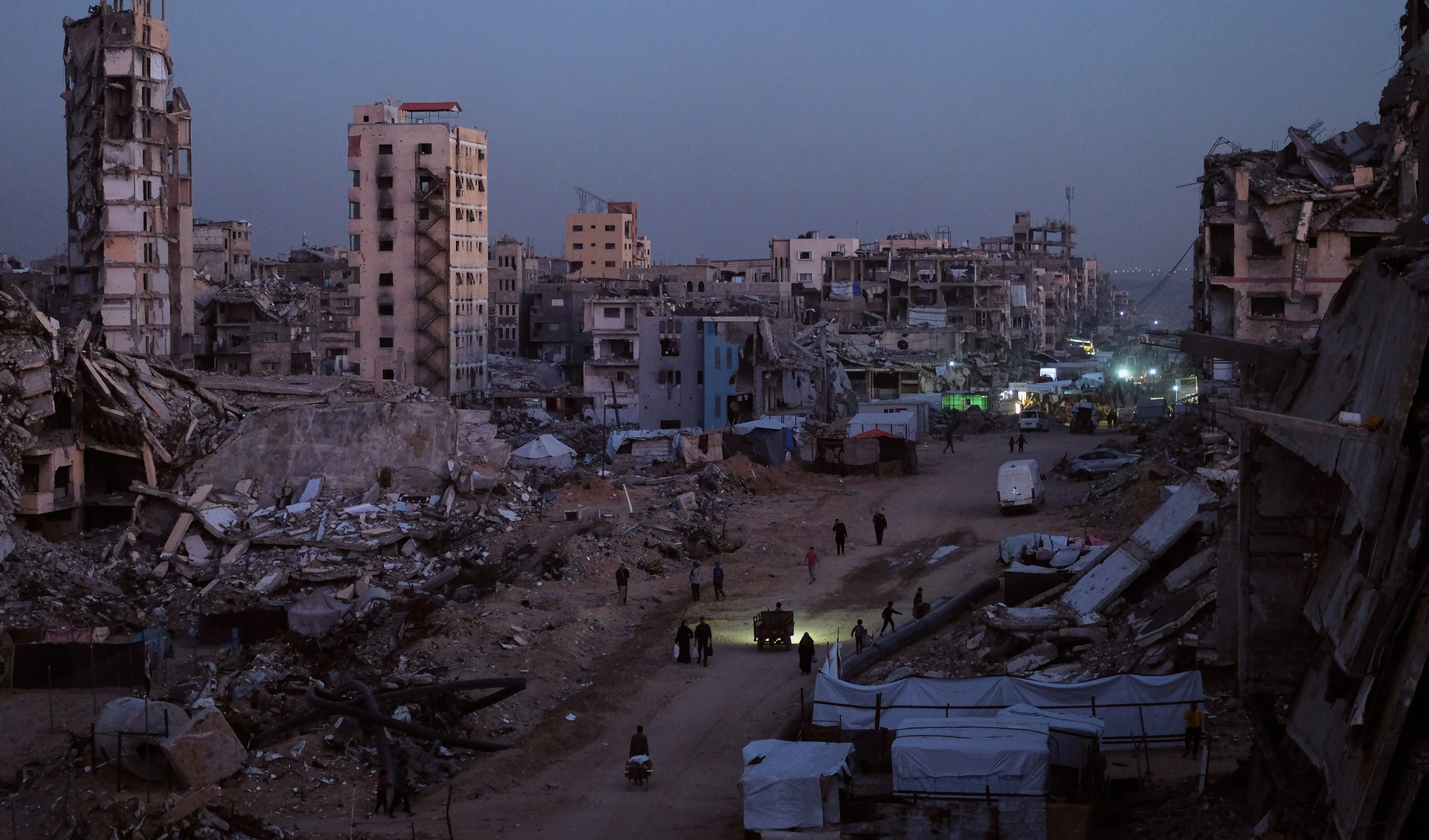 Palestinians walk through the destruction in the Al-Karama neighborhood of Gaza City Sunday, Nov. 30, 2025 (AP)