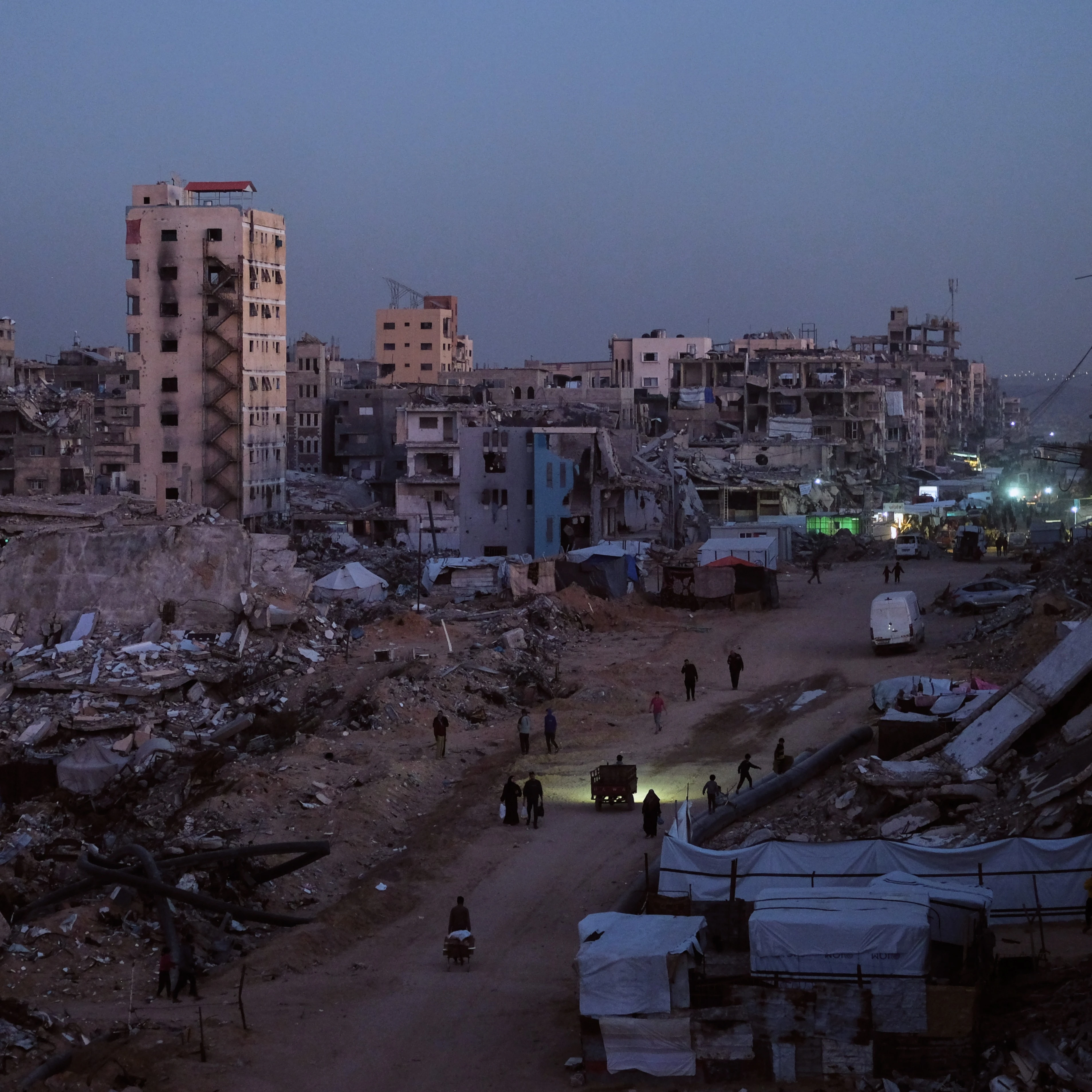 Palestinians walk through the destruction in the Al-Karama neighborhood of Gaza City Sunday, Nov. 30, 2025 (AP)