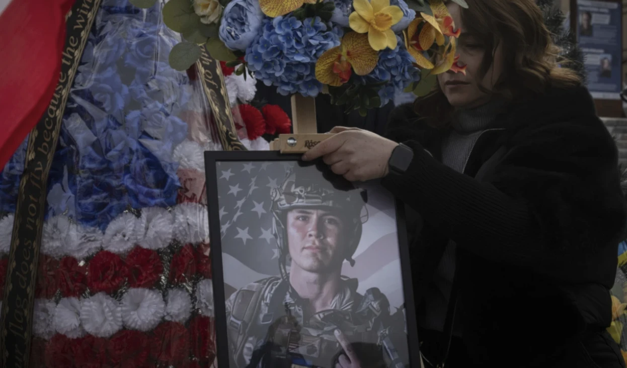 A woman holds a portrait of US Marine Corps veteran Ethan Hertweck who was killed in Ukraine during a funeral ceremony in Kiev, Ukraine on February 28, 2025. (AP)