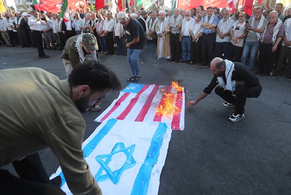 Palestinians protesters burn the Israeli and U.S flags during a protest against Israeli attacks on multiple cities across Iran, in the southern port city of Sidon, Lebanon, Saturday, June 21, 2025 (AP)