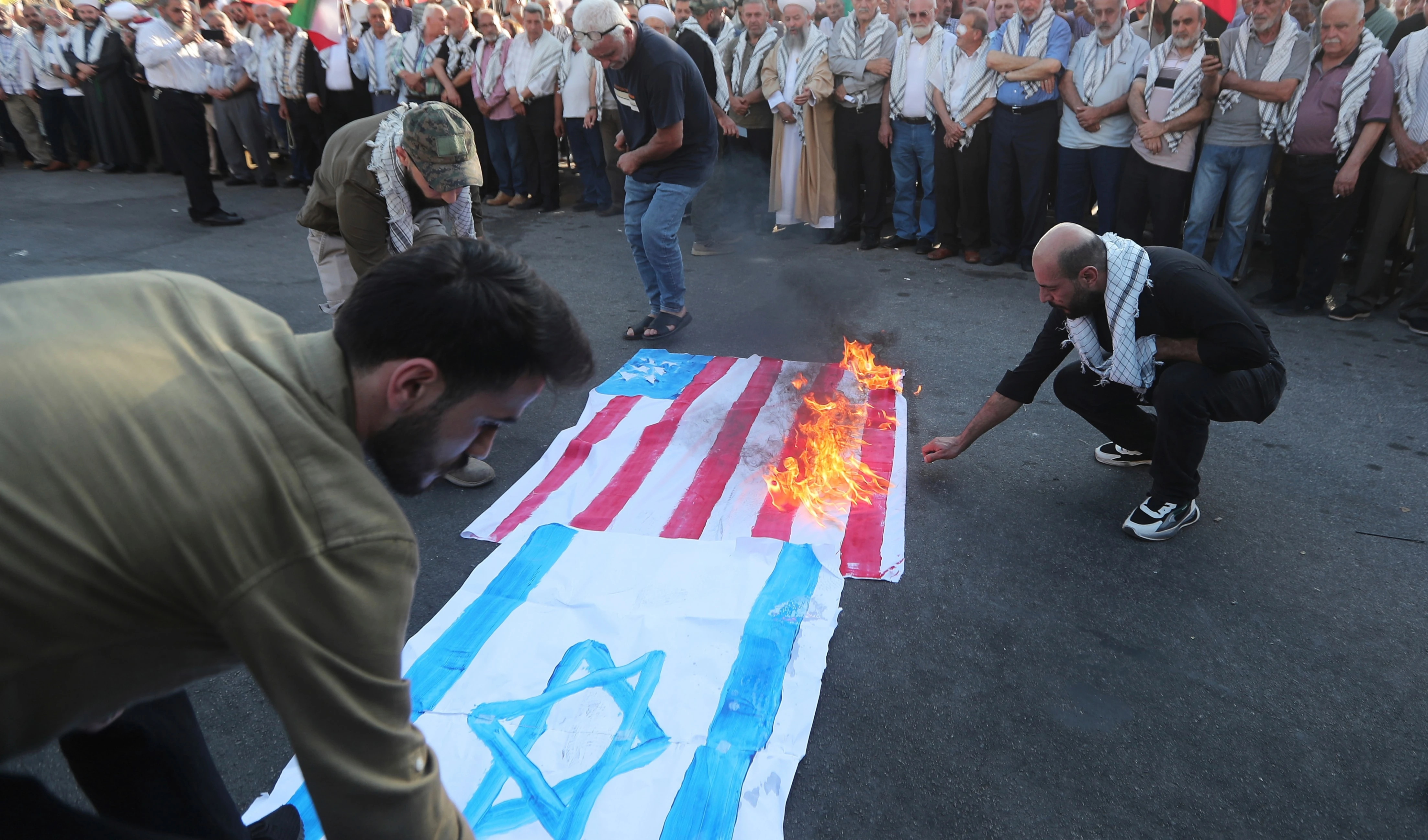 Palestinians protesters burn the Israeli and U.S flags during a protest against Israeli attacks on multiple cities across Iran, in the southern port city of Sidon, Lebanon, Saturday, June 21, 2025 (AP)