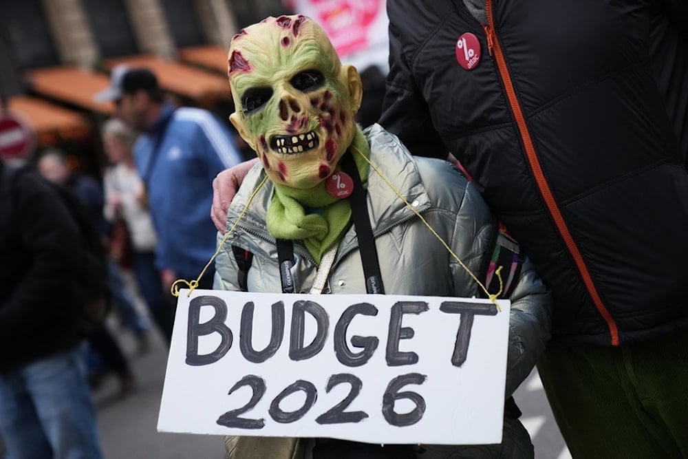 A protester holds a placard reading 