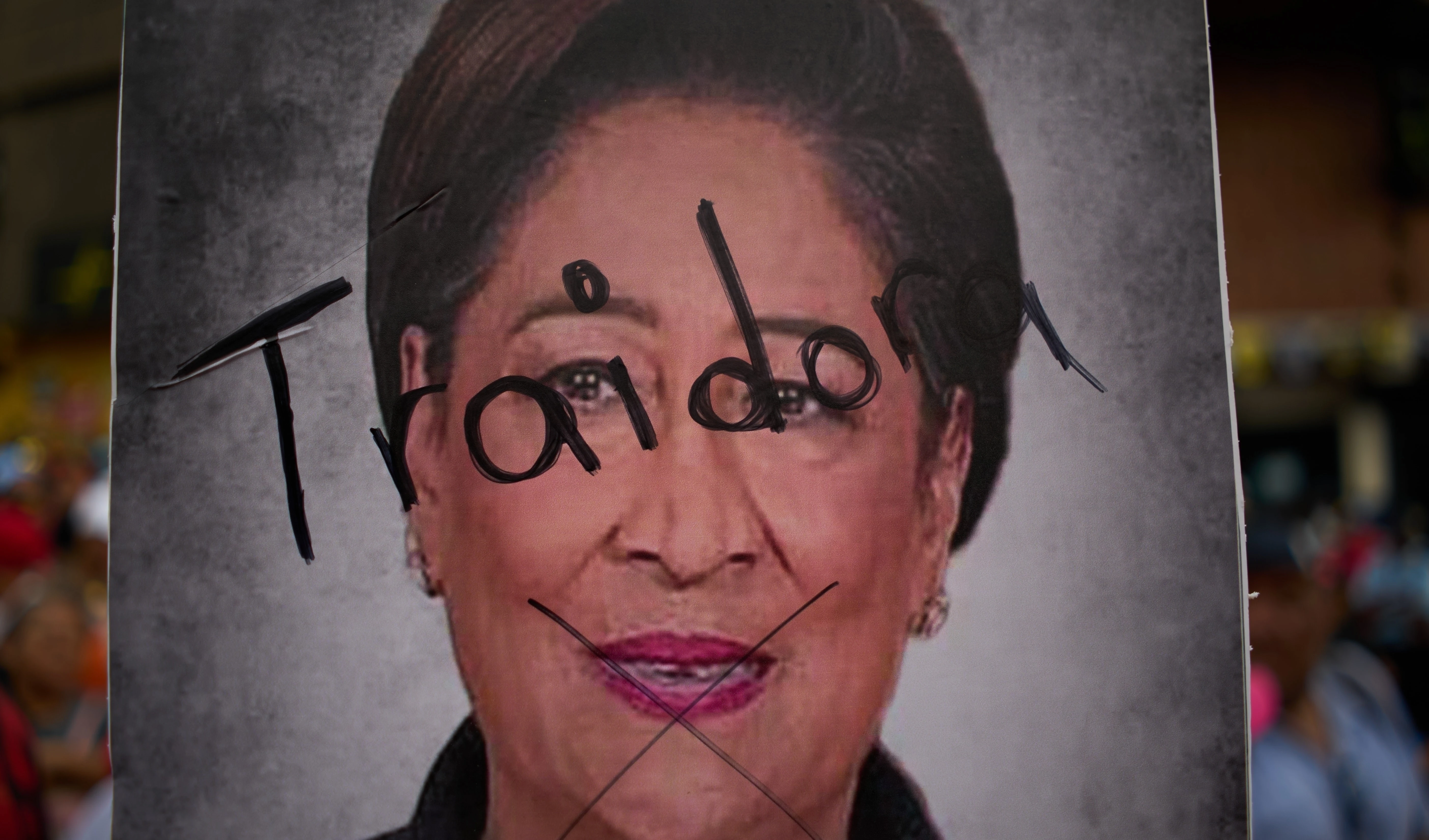 A poster of Trinidad and Tobago Prime Minister Kamla Persad-Bissessar hosts the Spanish word for "Traitor" on it during a government-organized march, in Caracas, Venezuela, Tuesday, Oct. 28, 2025 (AP)