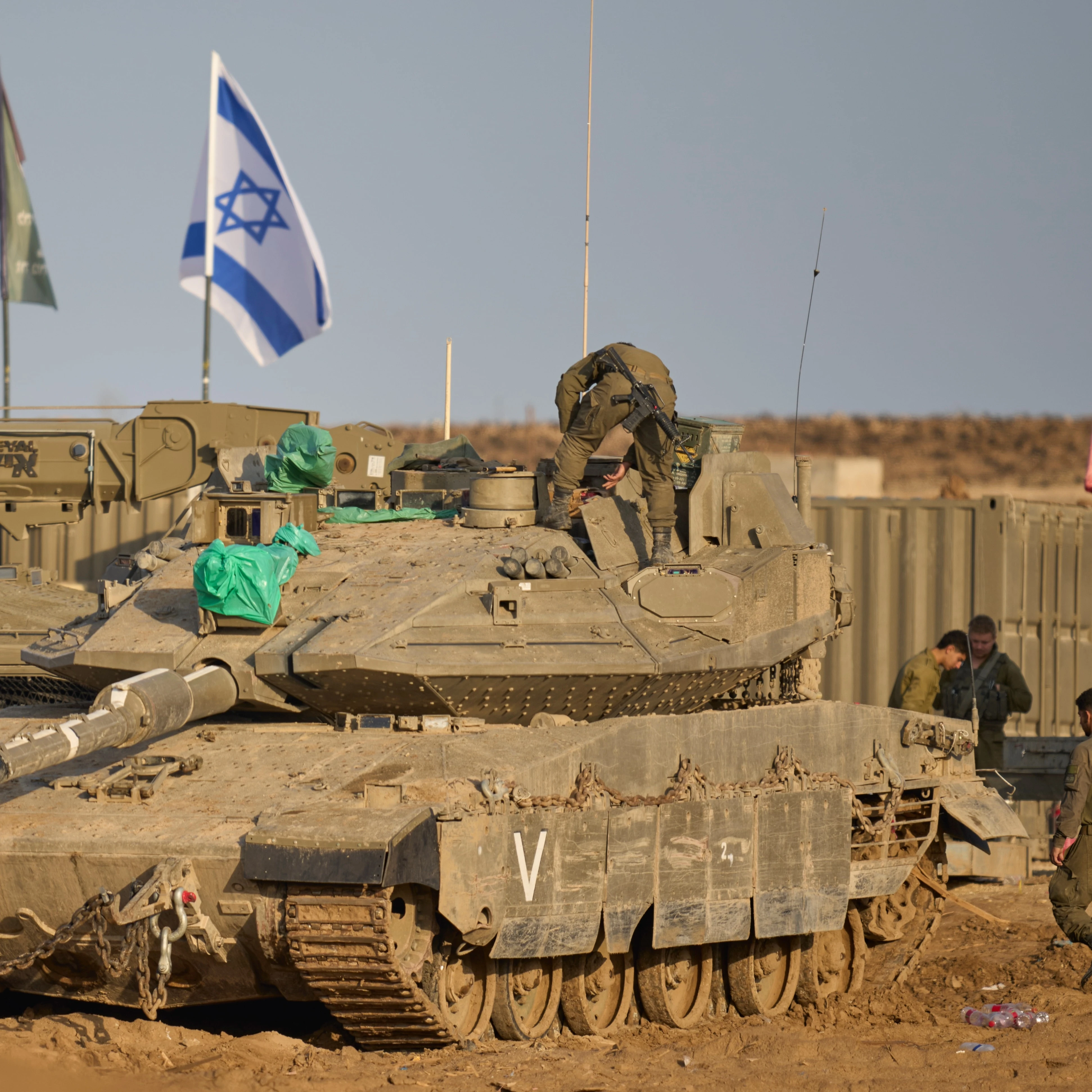 Israeli soldiers work on tanks at a staging area on the border with Gaza Strip, Occupied Palestine, Tuesday, Nov. 18, 2025 (AP)