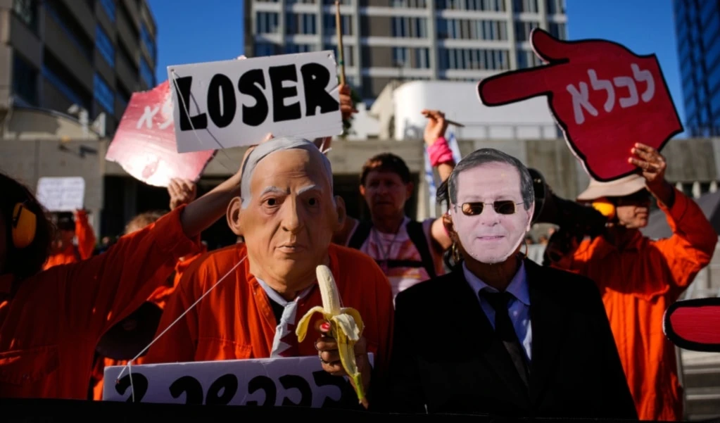 People protest against Israeli Prime Minister Benjamin Netanyahu outside a court in occupied Jaffa on Monday, December 1, 2025, a day after he asked the country's president for a pardon amid his ongoing corruption trial. (AP Photo/Ohad Zwigenberg)