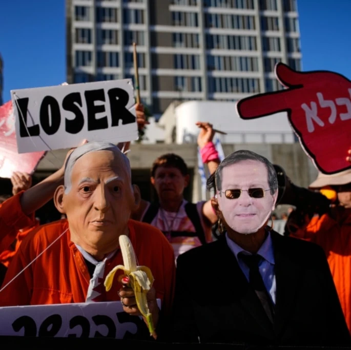 People protest against Israeli Prime Minister Benjamin Netanyahu outside a court in occupied Jaffa on Monday, December 1, 2025, a day after he asked the country's president for a pardon amid his ongoing corruption trial. (AP Photo/Ohad Zwigenberg)