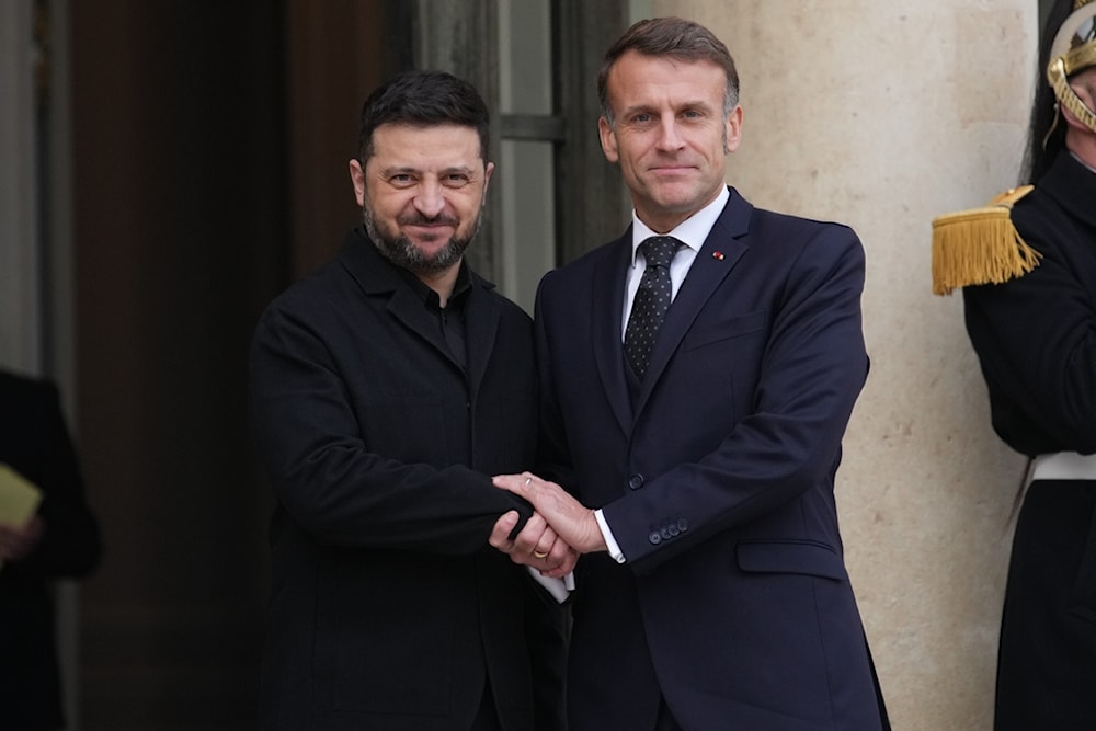 French President Emmanuel Macron, right, welcomes Ukrainian President Volodymyr Zelensky, Monday, December 1, 2025 before a meeting at the Elysee Palace in Paris. (AP Photo/Christophe Ena)
