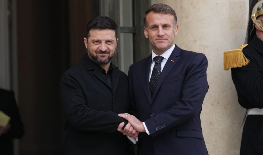French President Emmanuel Macron, right, welcomes Ukrainian President Volodymyr Zelensky, Monday, December 1, 2025 before a meeting at the Elysee Palace in Paris. (AP Photo/Christophe Ena)