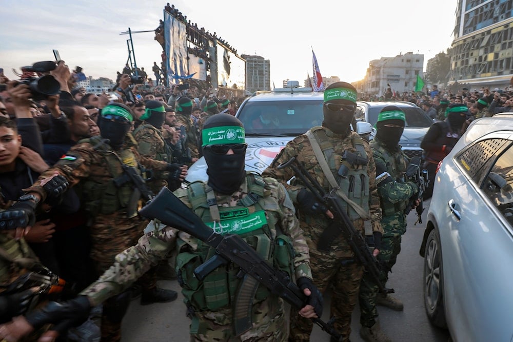 Hamas fighters escort a Red Cross vehicle to collect Israeli hostages released after a ceasefire agreement between Israel and Hamas took effect, in Gaza City on January 19, 2025. (AP Photo/Abed Hajjar)