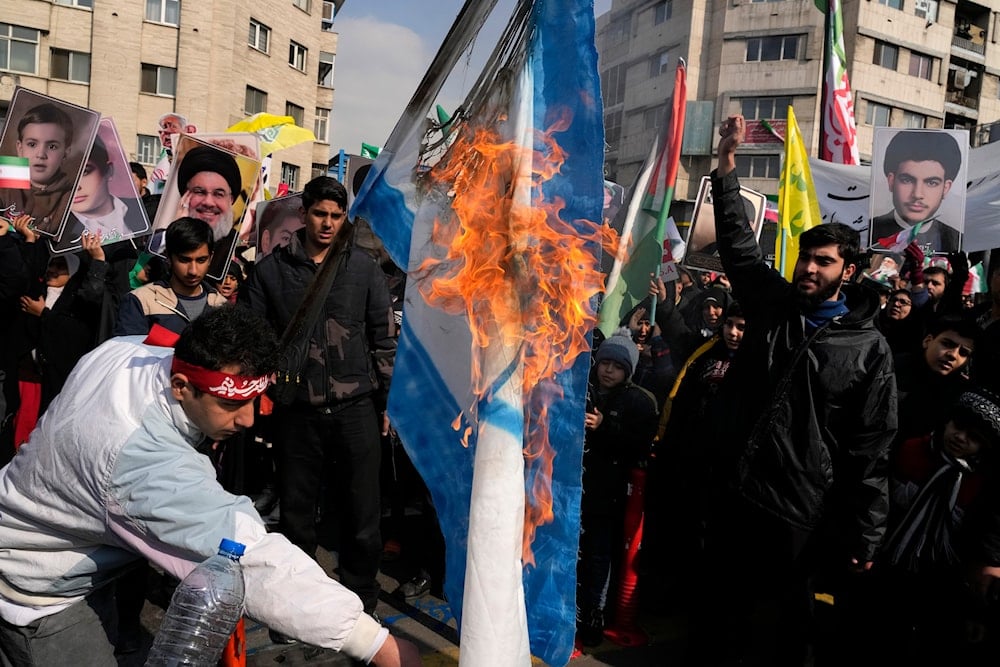  Iranian demonstrators burn a representation of the Israeli flag during a rally commemorating anniversary of 1979 Islamic Revolution that toppled the late pro-U.S. Shah Mohammad Reza Pahlavi, Iran, Monday, Feb. 10, 2025. (AP)