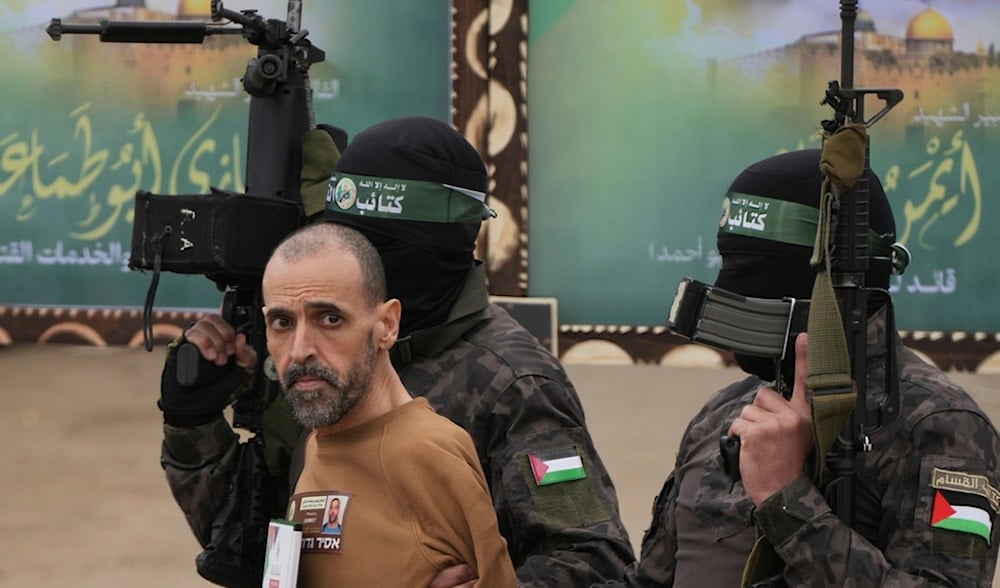 An Israeli captive is escorted by Hamas fighters before being handed over to the Red Cross in Deir al-Balah, central Gaza Strip, Saturday Feb. 8, 2025. (AP)