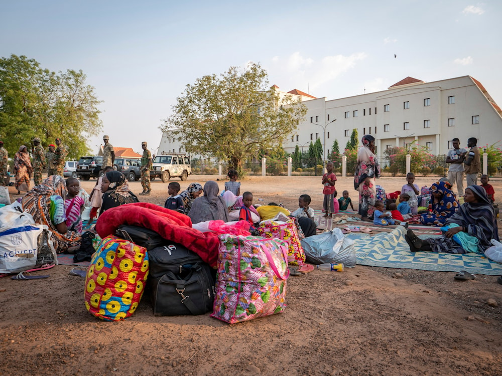  Sudanese nationals sit outside the South Sudan People's Defense Forces (SSPDF) headquarters, after a night of violence in Juba, South Sudan, on Friday, Jan. 17, 2025. (AP)