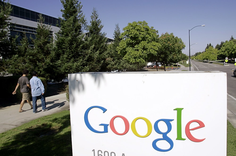  In this July 17, 2006 file photo, Google workers walk by a Google sign at company headquarters in Mountain View, Calif.(AP)