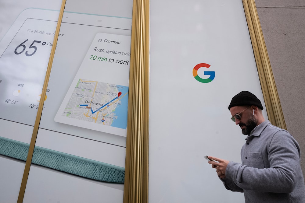 A man using a mobile phone walks past Google offices, Monday, Dec. 17, 2018, in New York. (AP)