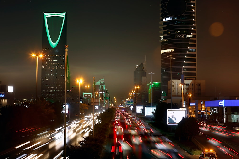 In this Sept. 22, 2019 file photo taken with a slow shutter speed, vehicles pass in front of the landmark Kingdom Tower, at left, during celebrations marking Saudi 89th National Day, in Riyadh, Saudi Arabia.