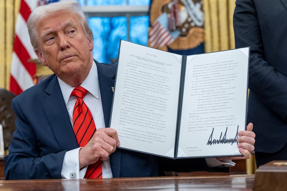 President Donald Trump holds up a signed an executive order, Monday, Feb. 10, 2025 (AP)