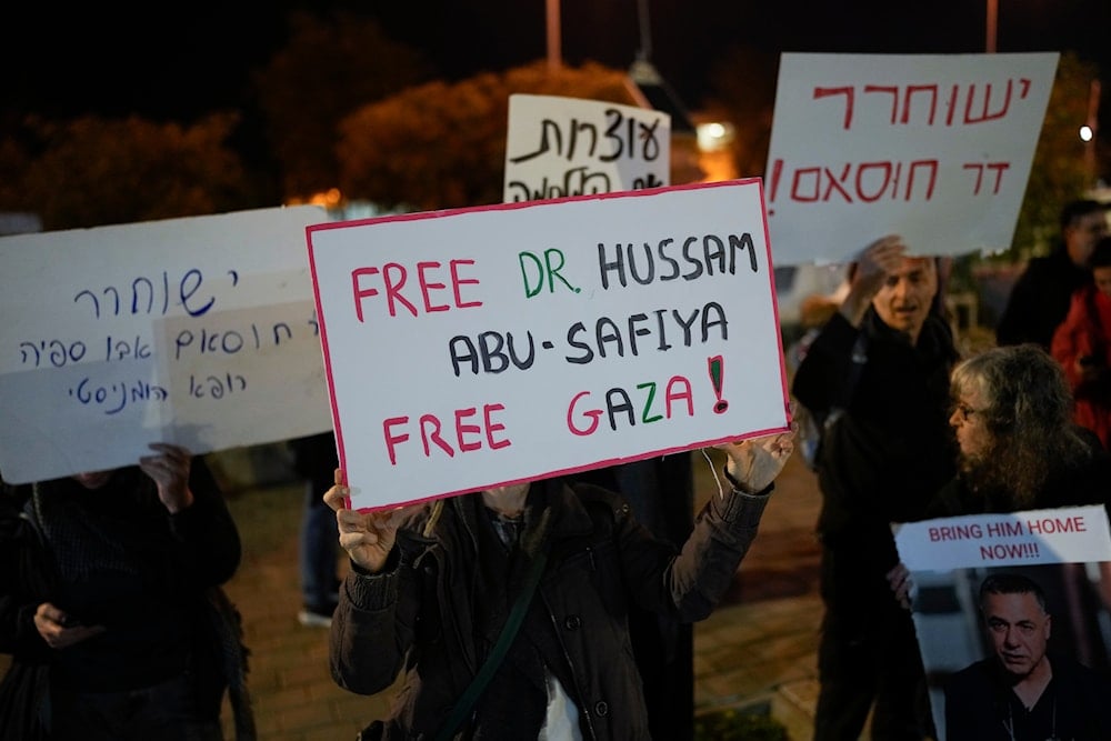 A woman holds a sign that reads 