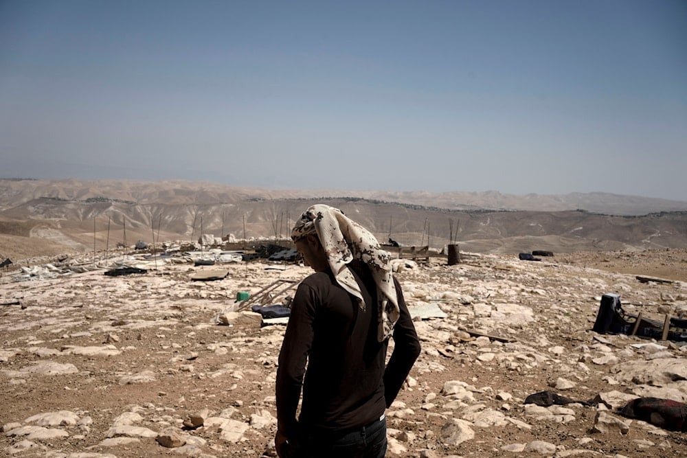 Palestinian shepherd Mustafa Arara, 24, stands in the ruins of the West Bank Bedouin village of al-Baqa, Aug. 9, 2023 (AP)