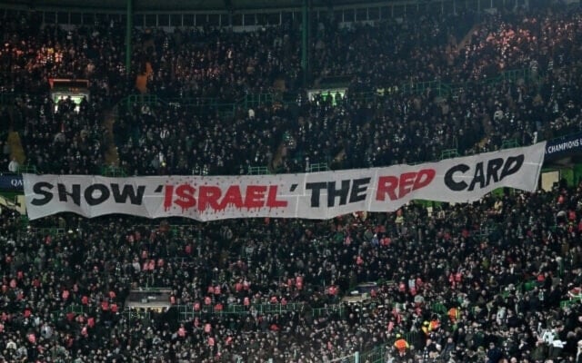 Celtic fans unveil a banner reading 'Show Israel The Red Card' during the UEFA Champions League play-off first leg football match between Celtic and Bayern Munich at Celtic Park stadium in Glasgow, Scotland on February 12, 2025.