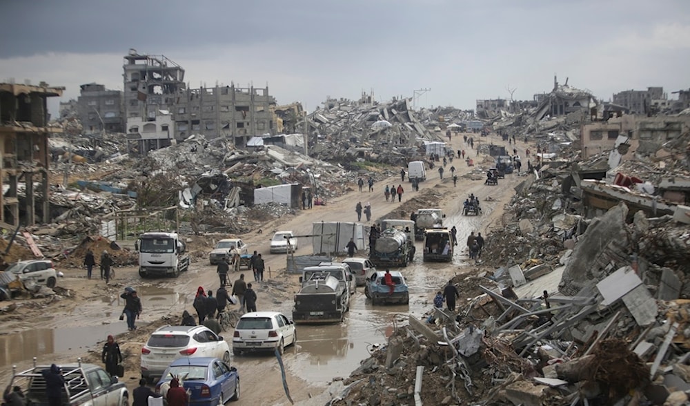 Cars and pedestrians move along a road amid widespread destruction caused by the Israeli war in Gaza City's Jabalia refugee camp, Friday, Feb. 7, 2025. (AP)