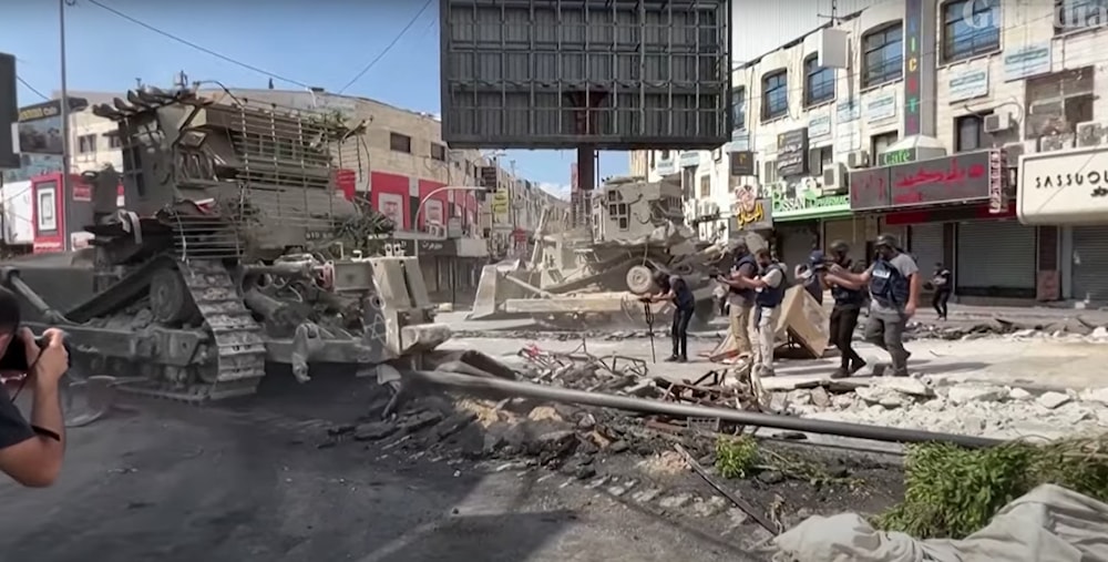 Reporters take pictures of an Israeli bulldozer in Jenin. (Screengrab)