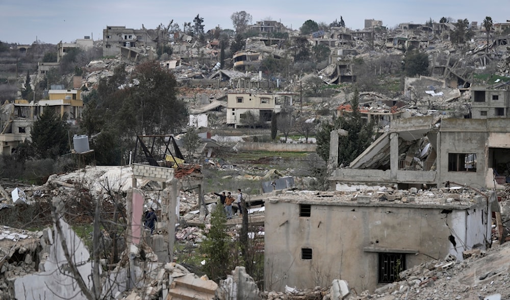 Lebanese citizens, centre, check the destruction caused by the Israeli occupation in Aita al-Shaab, south Lebanon, Sunday, Jan. 26, 2025. (AP)