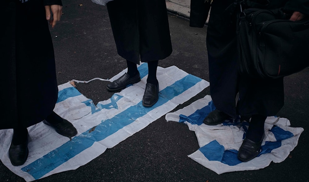 Haredi Jews step on the Israeli flag to protest against Prime Minister Benjamin Netanyahu in front of his hotel during the 79th session of the United Nations General Assembly, in New York, on Friday, Sept. 27, 2024. (AP)