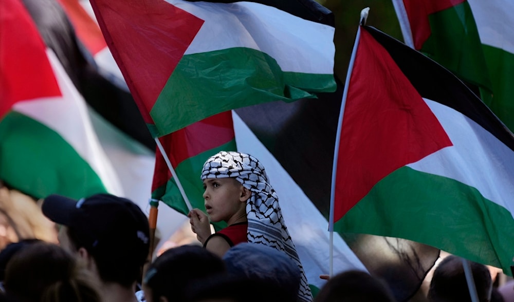 A young boy waves his flag among others as people gather in central Sydney for a rally Sunday, Oct. 15, 2023, to support Palestinians in Gaza. (AP)