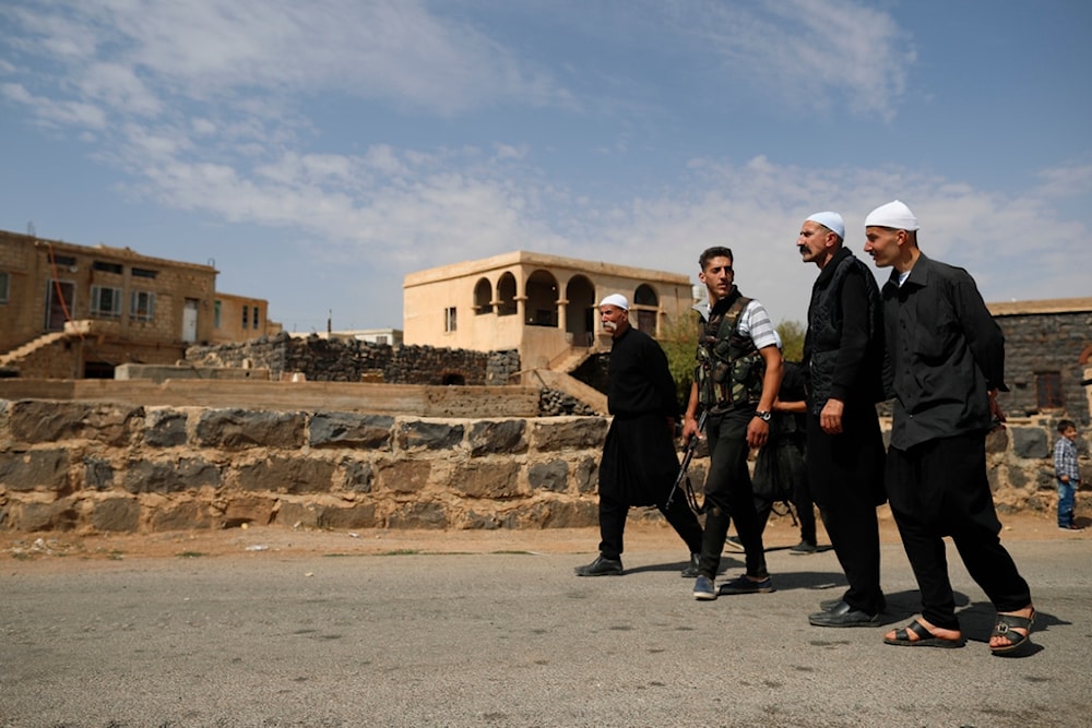 Druze men walk in the village of Rami in the southern province of Suweida, Syria, Thursday, Oct. 4, 2018