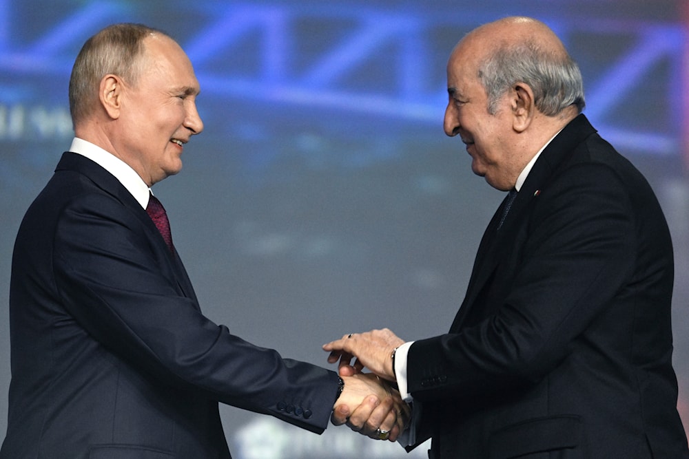 Russian President Vladimir Putin, left, and Algerian President Abdelmadjid Tebboune shake hands at a plenary session of the St. Petersburg International Economic Forum, June 16, 2023 (AP)