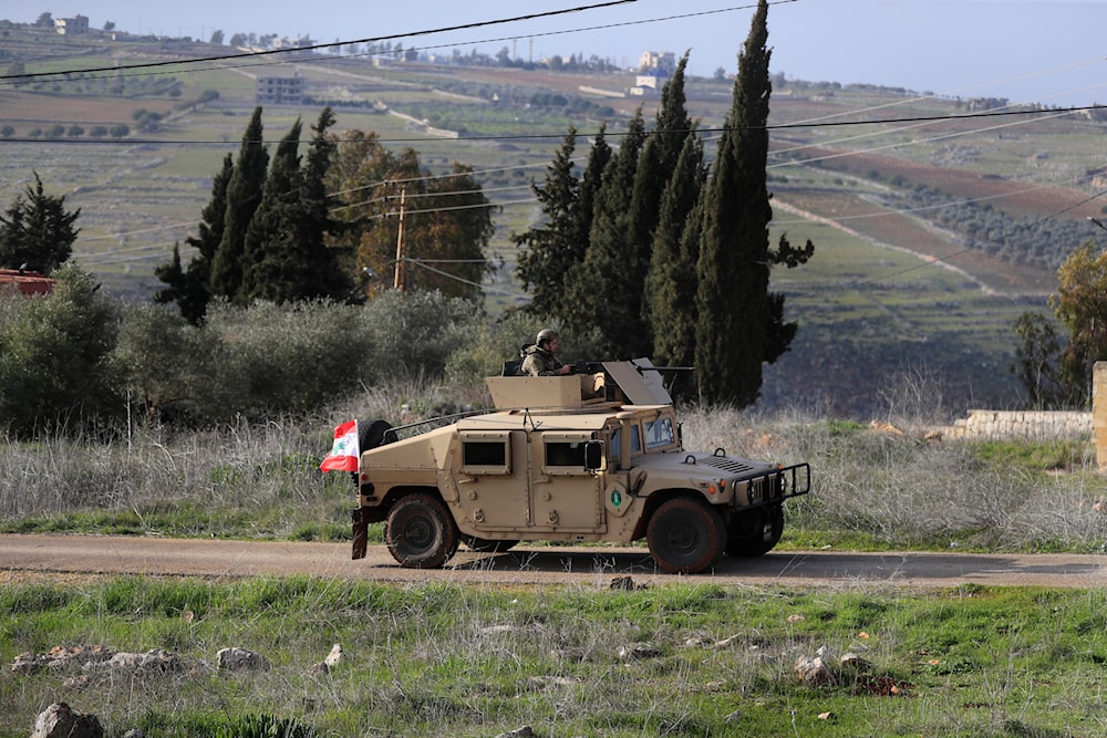 A Lebanese army vehicle patrols at a road that links to Houla village, where the Israeli forces still deploy inside it, in south Lebanon, Monday, Feb. 17, 2025. (AP Photo/Mohammed Zaatari)