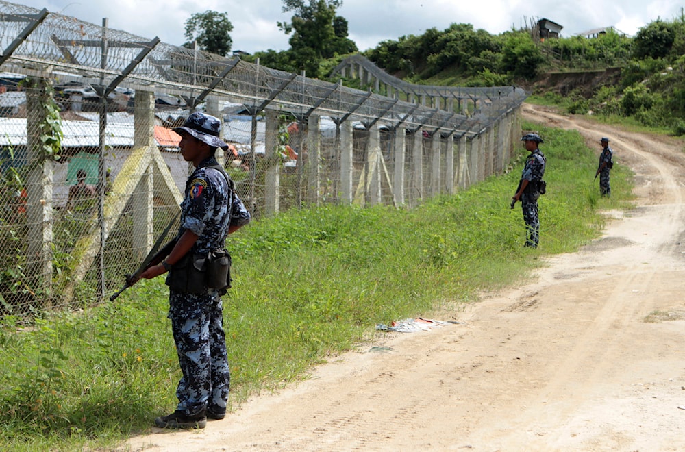 Myanmar border guards stand to provide security near the fence at a no-man's land between Myanmar and Bangladesh, near Taungpyolatyar village, Maungdaw, northern Rakhine State, Myanmar, on June 29, 2018. (AP)