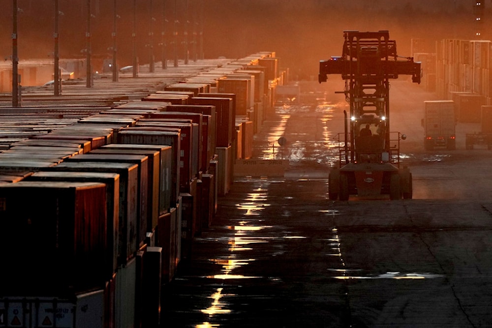 A worker drives among shipping containers at a BNSF railroad intermodal terminal, Sunday, Dec. 29, 2024, in Edgerton, Kan. (AP Photo/Charlie Riedel)