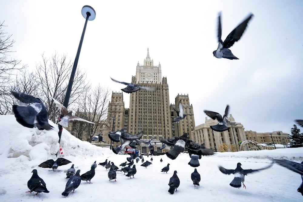 Pigeons take off in front of the Russian Foreign Ministry building in Moscow, Russia, Wednesday, Jan. 26, 2022 (AP)