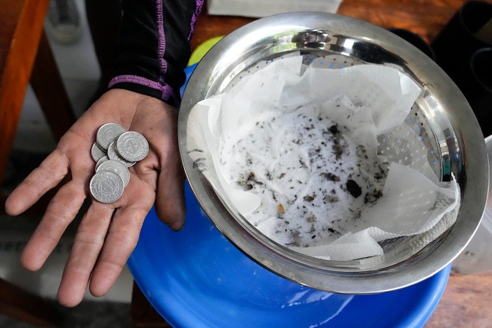 Michael Labag shows the 9 pesos reward he got from the 45 mosquito larvas he captured in Mandaluyong city, Philippines, February 19 2025 (AP)