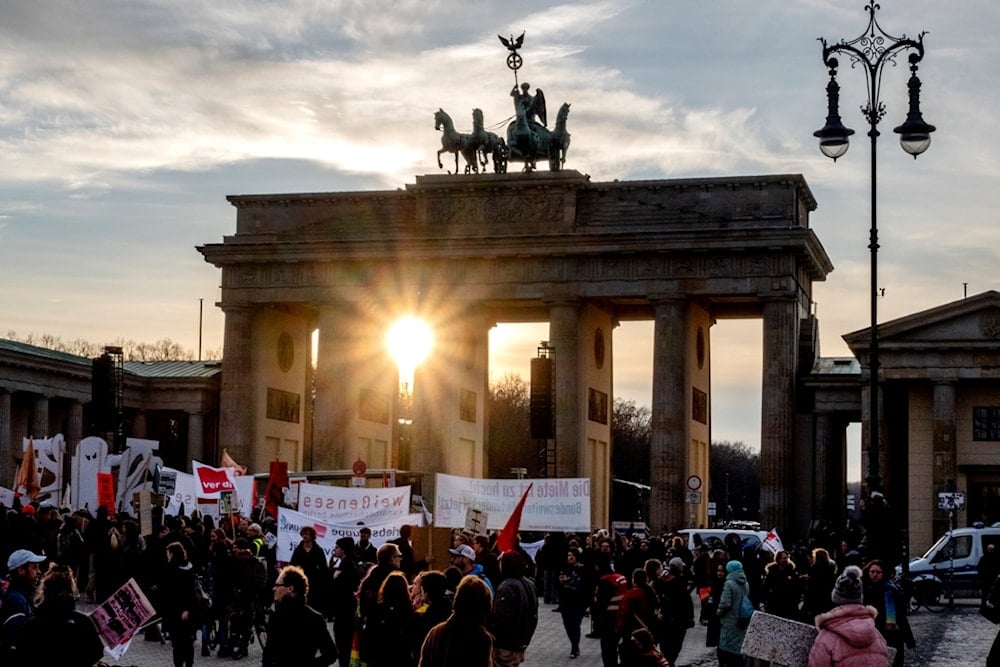 The sun sets behind the Brandenburg Gate in Berlin, Germany, Saturday, Feb. 22, 2025, one day ahead of the German election. (AP Photo/Michael Probst)