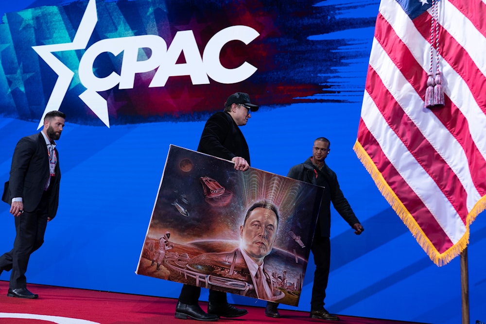 Elon Musk holds a painting after speaking at the Conservative Political Action Conference, CPAC, at the Gaylord National Resort & Convention Center, Thursday, Feb. 20, 2025, in Oxon Hill, Md. (AP)